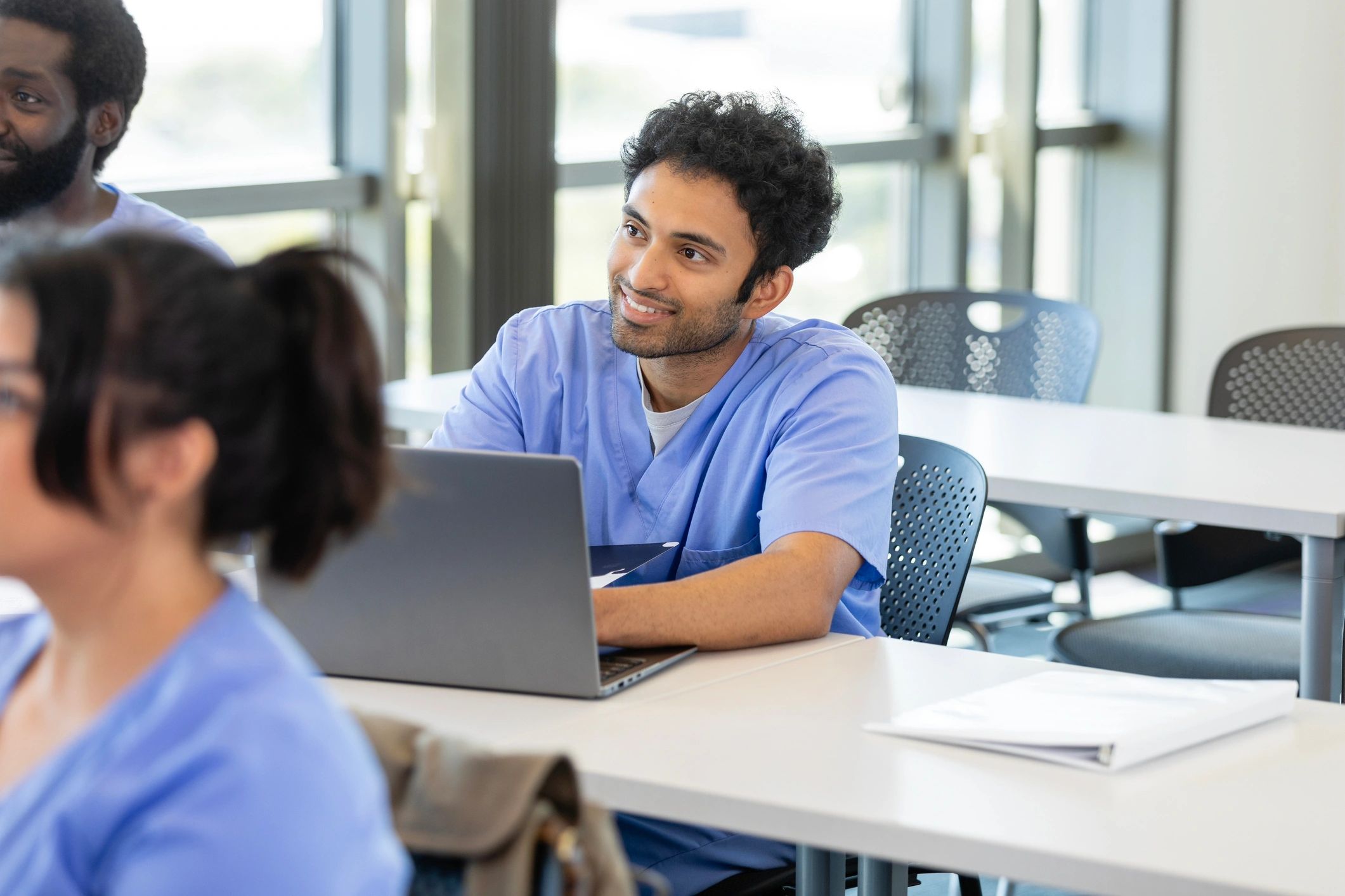 Medical student taking notes on a laptop